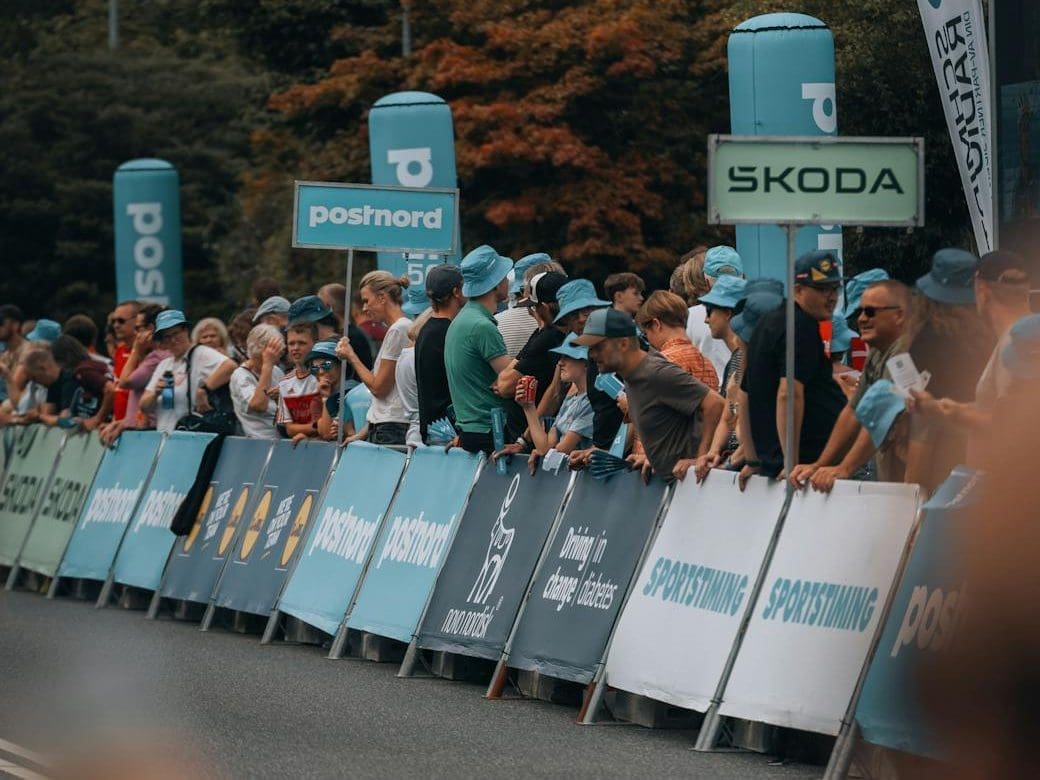 a crowd of people standing behind a barrier