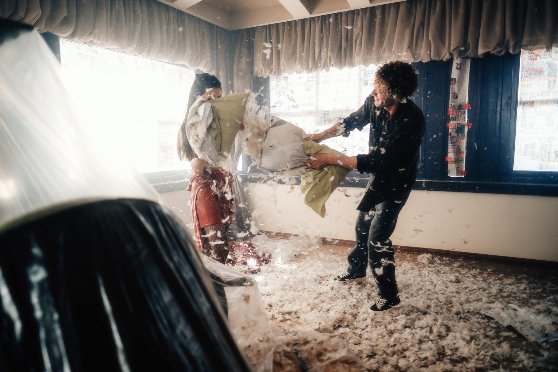 playful pillow fight with feathers flying