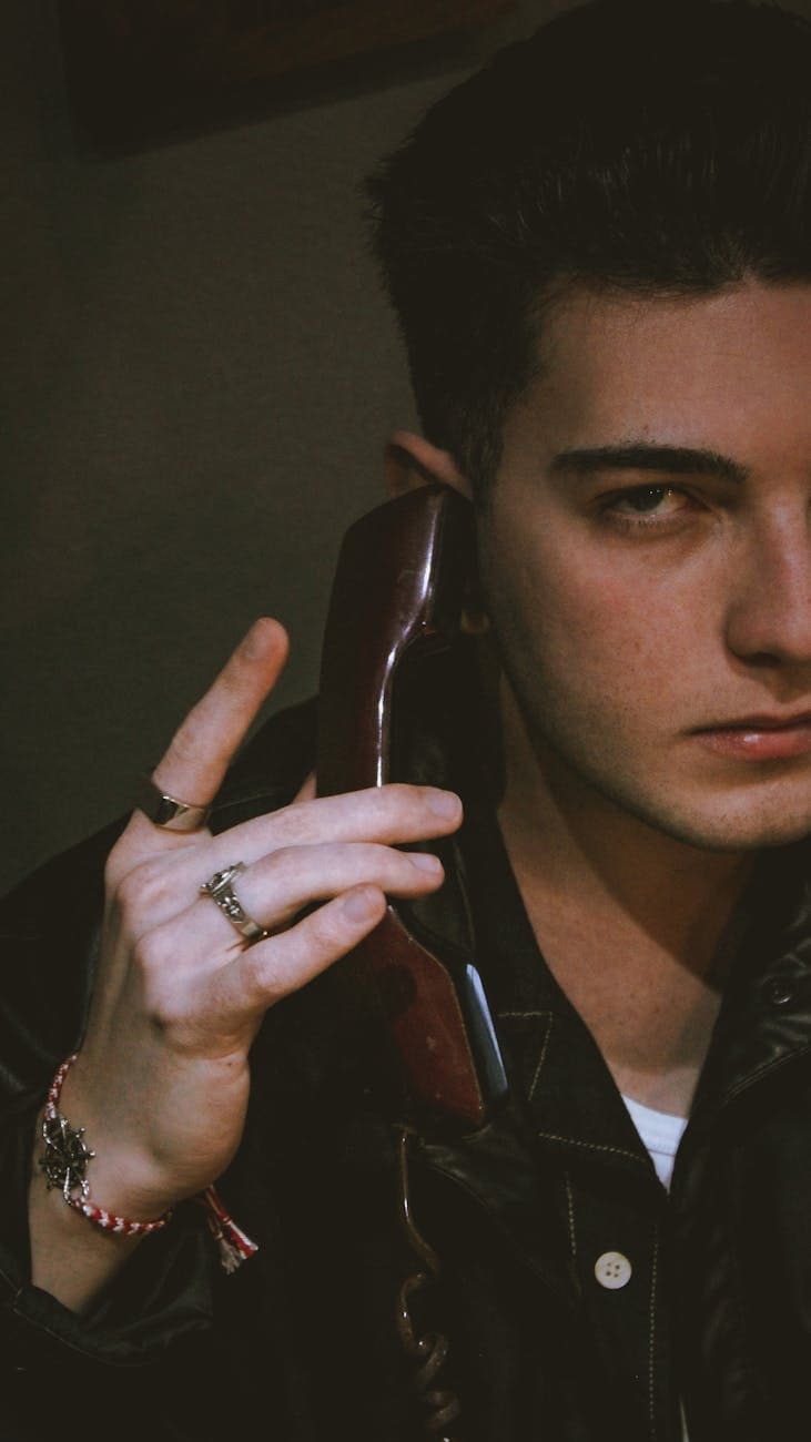 moody portrait of a young man with vintage phone