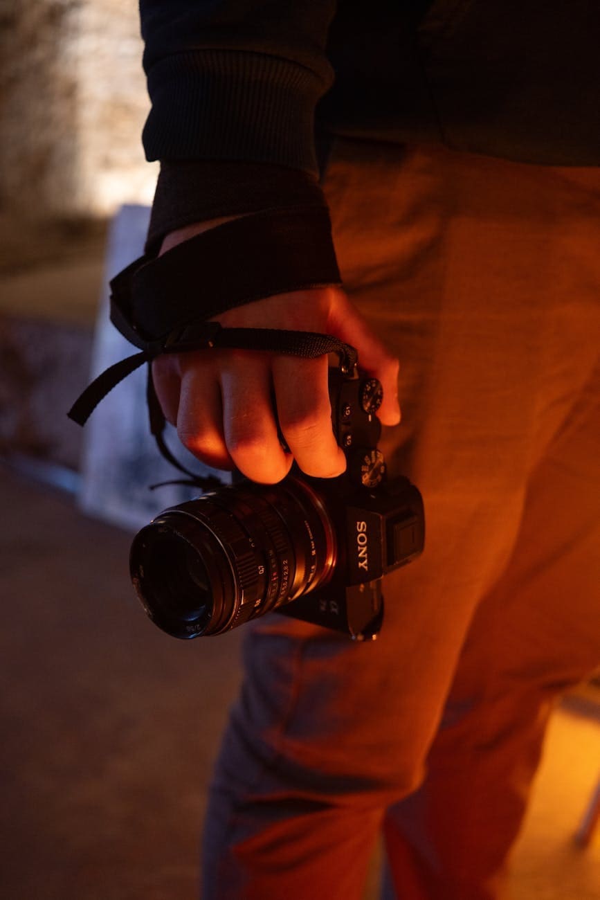 close up of a person holding a camera indoors