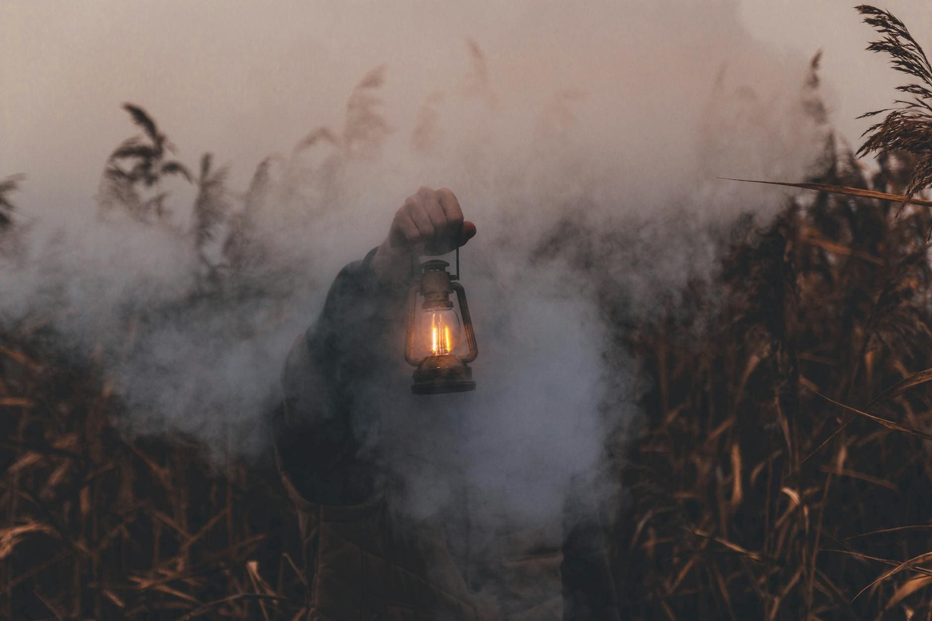 person holding kerosene lantern