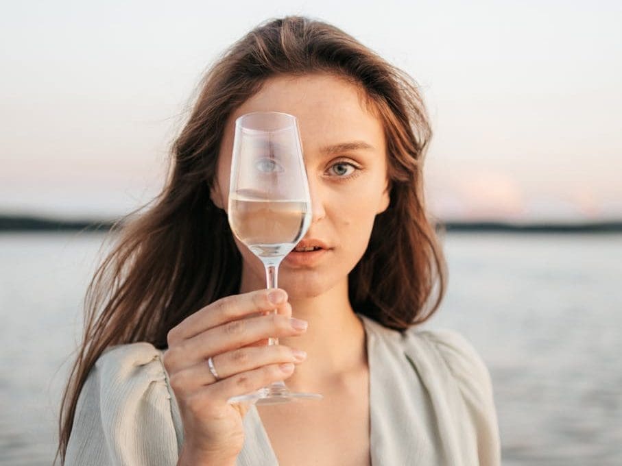 woman holding clear champagne glass