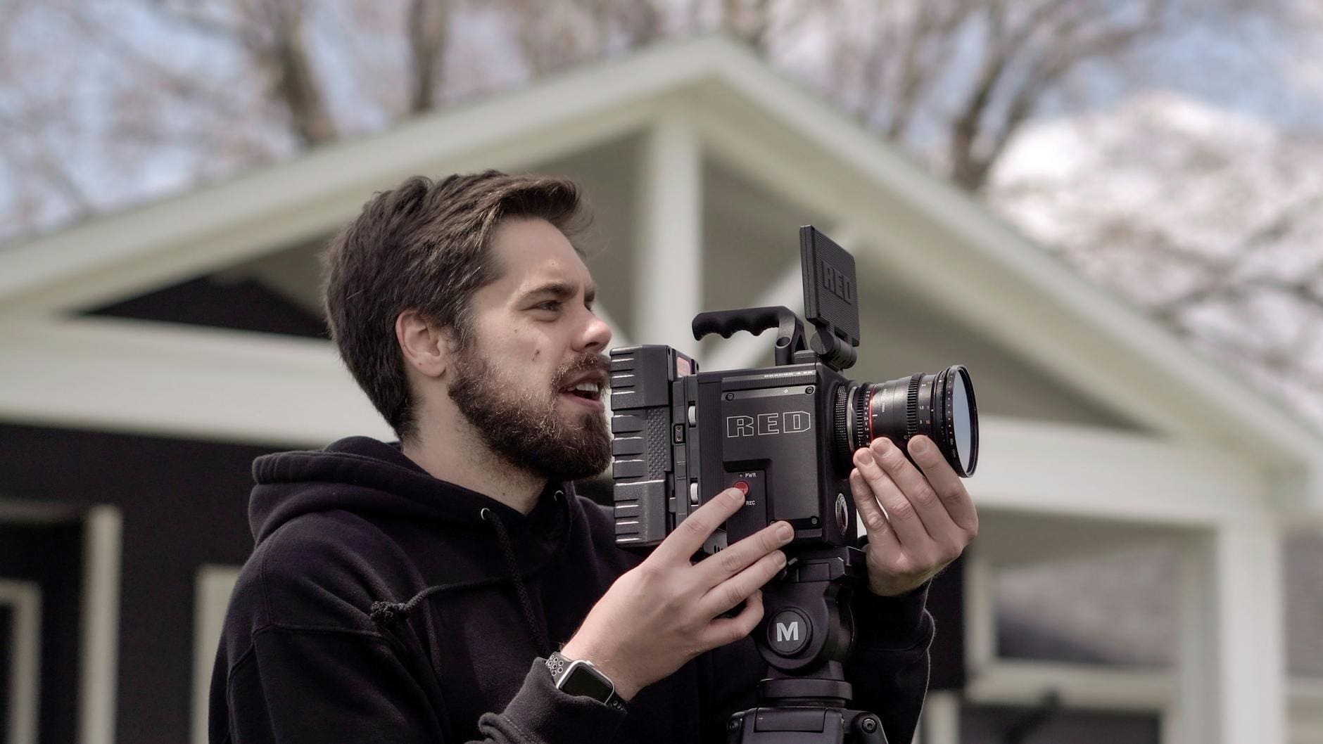 man in black hoodie jacket holding black dslr camera