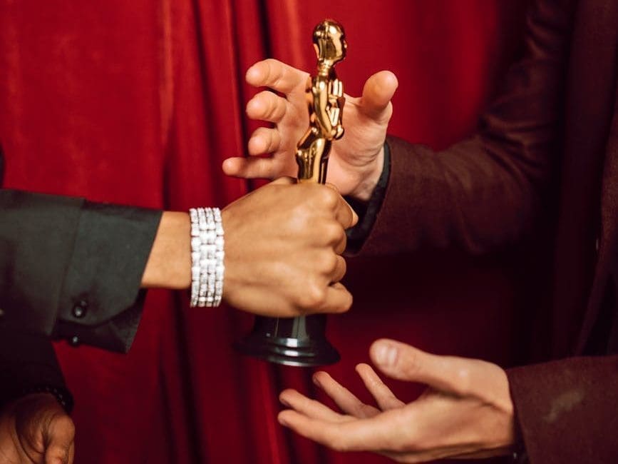 hands of a man receiving a gold trophy