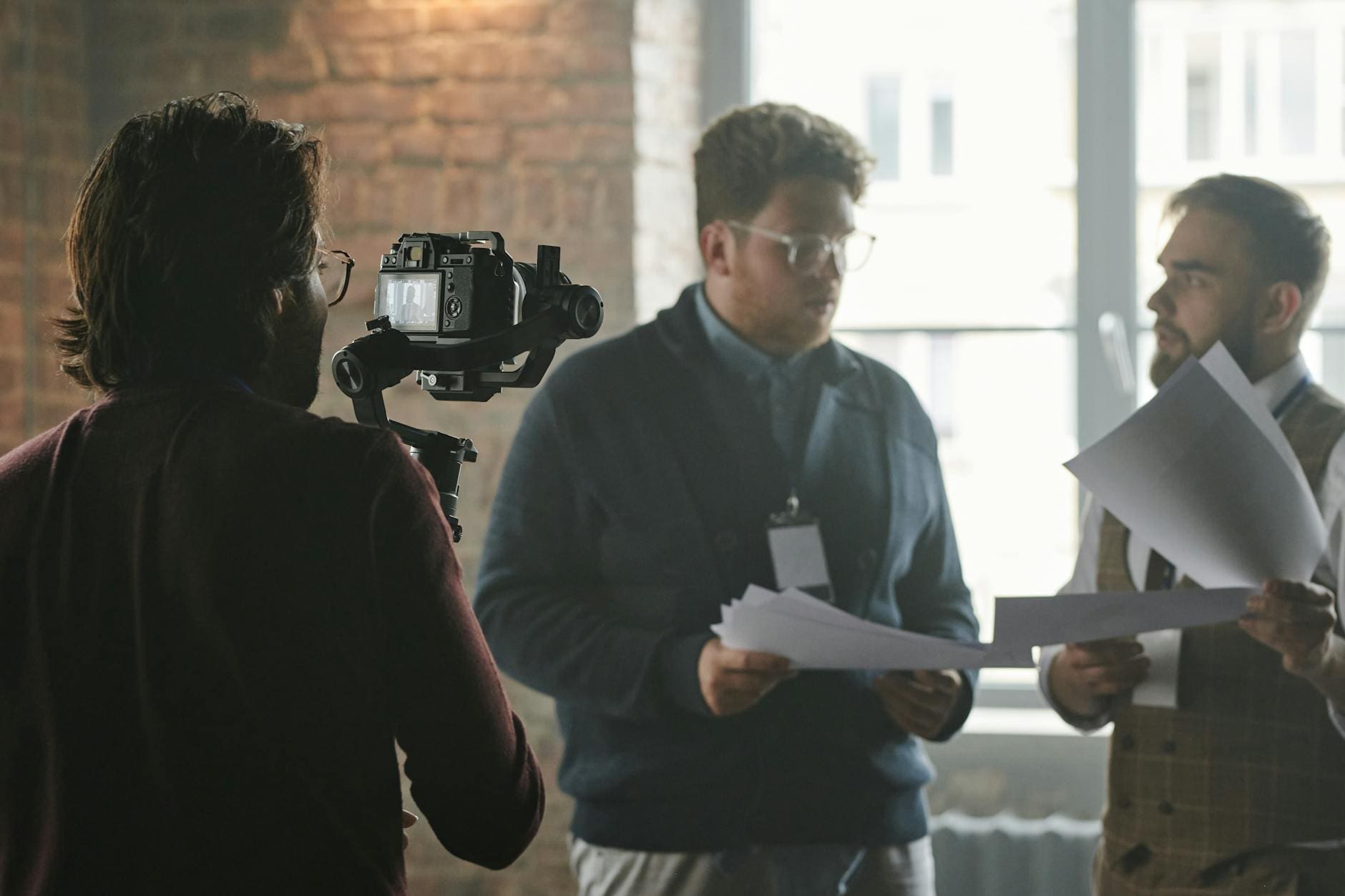 person taking a video of men holding papers
