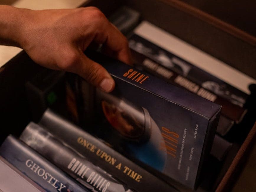someone choosing a film from various videotapes