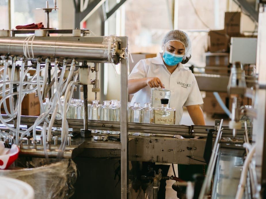 worker holding glass bottles