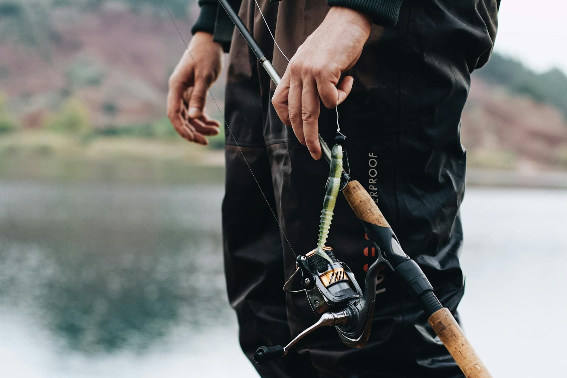 person in black long sleeve shirt holding fishing rod with fish