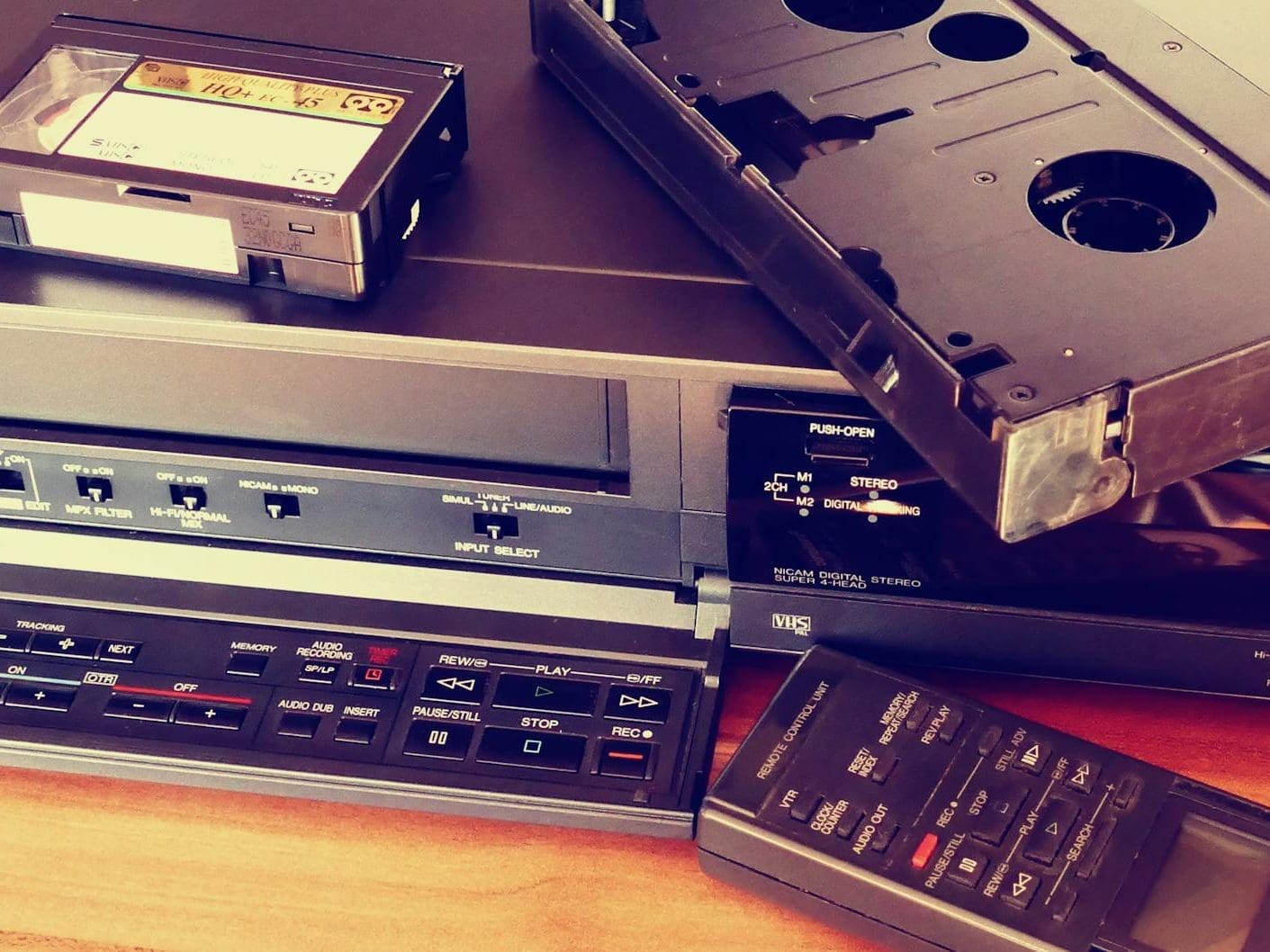 black vhs on vhs player beside remote control