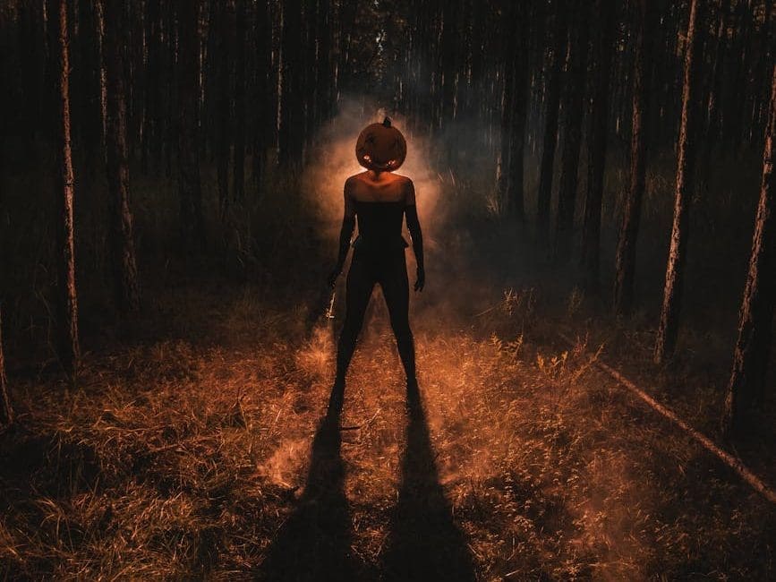 man in a pumpkin costume in forest