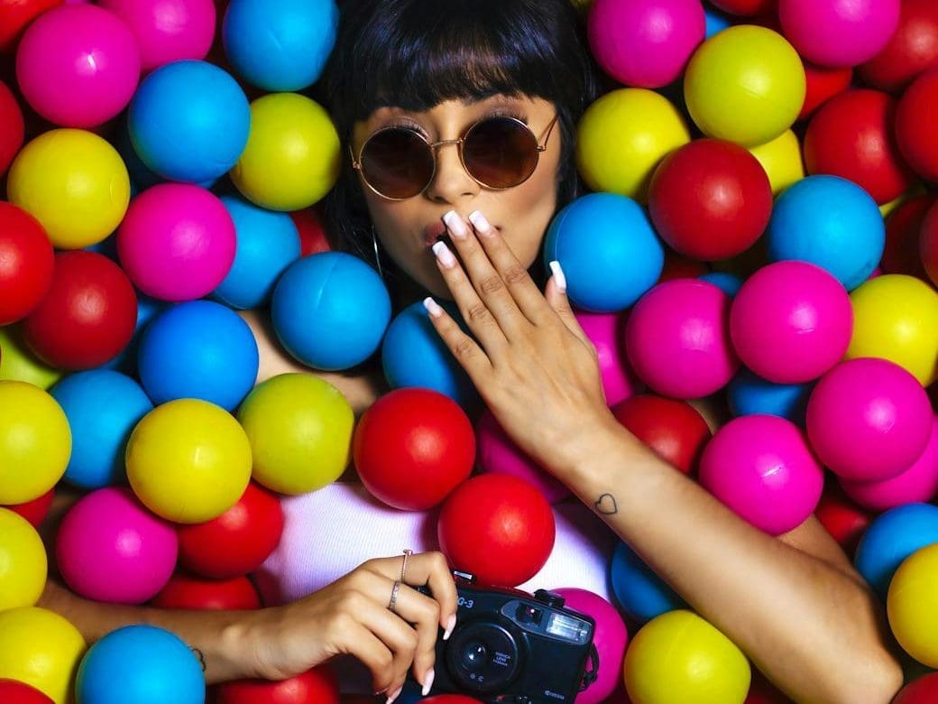 woman holding dslr camera while touching her lips