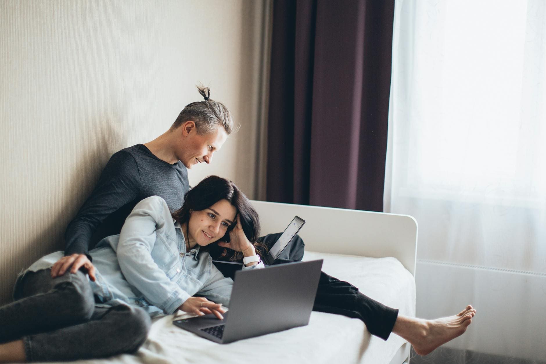 couple sitting on the bed working