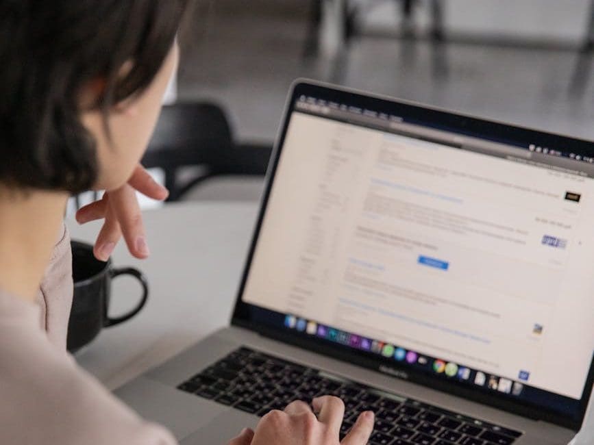 crop unrecognizable businesswoman typing on laptop at home