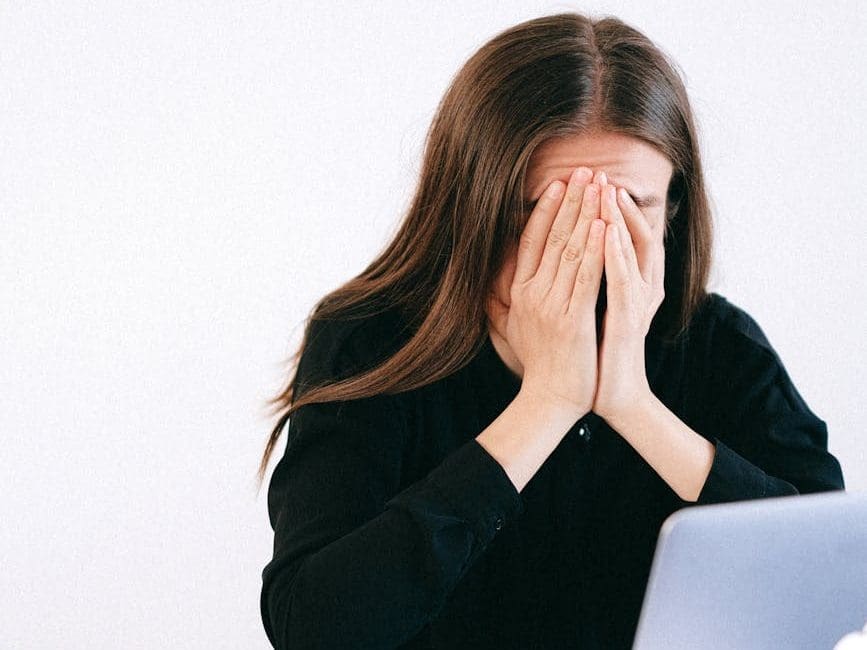 stressed woman covering her face with her hands