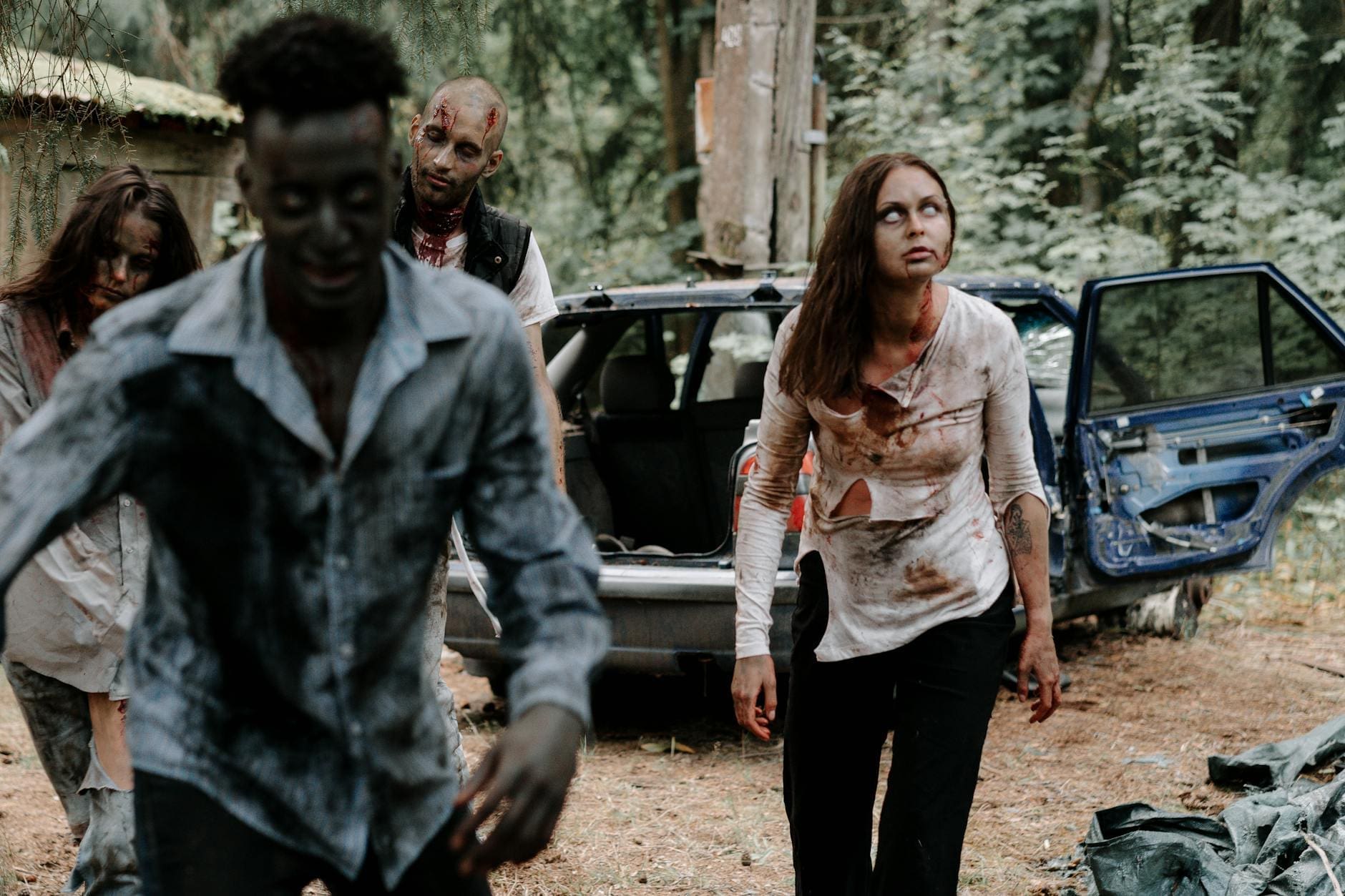 zombies near an abandoned car