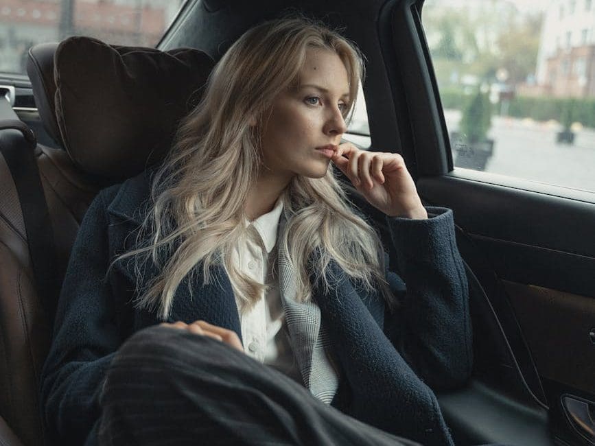 woman in a coat inside a car