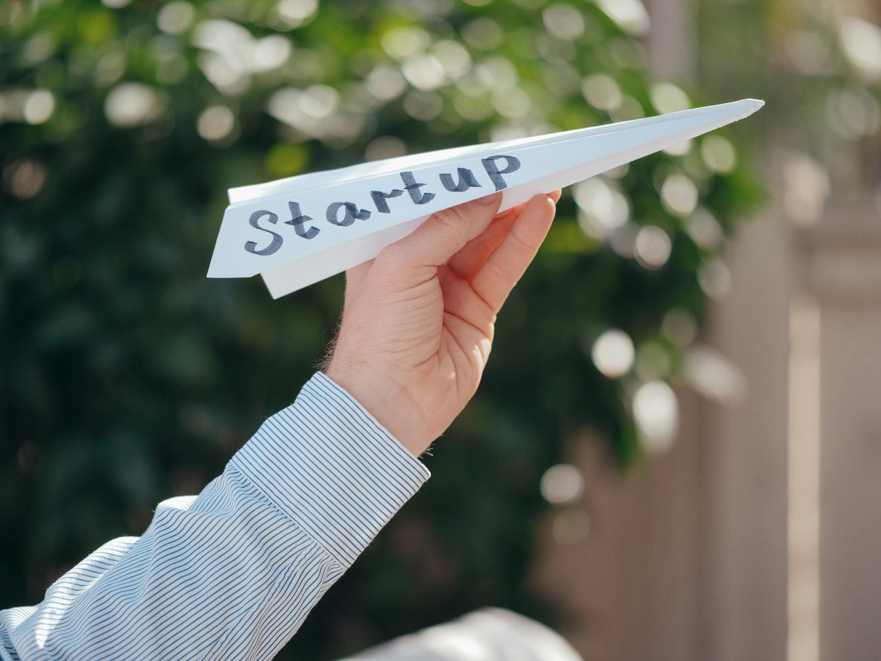 close up shot of a person holding a paper plane