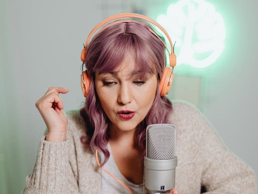 a woman talking on a microphone while wearing a headphone