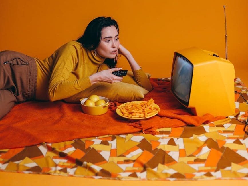 woman in yellow long sleeve shirt watching tv