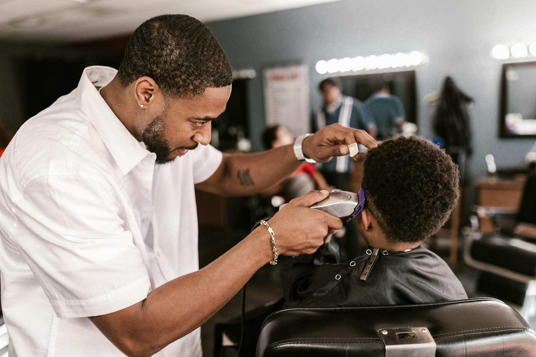 man in white dress shirt shaving boy s hair