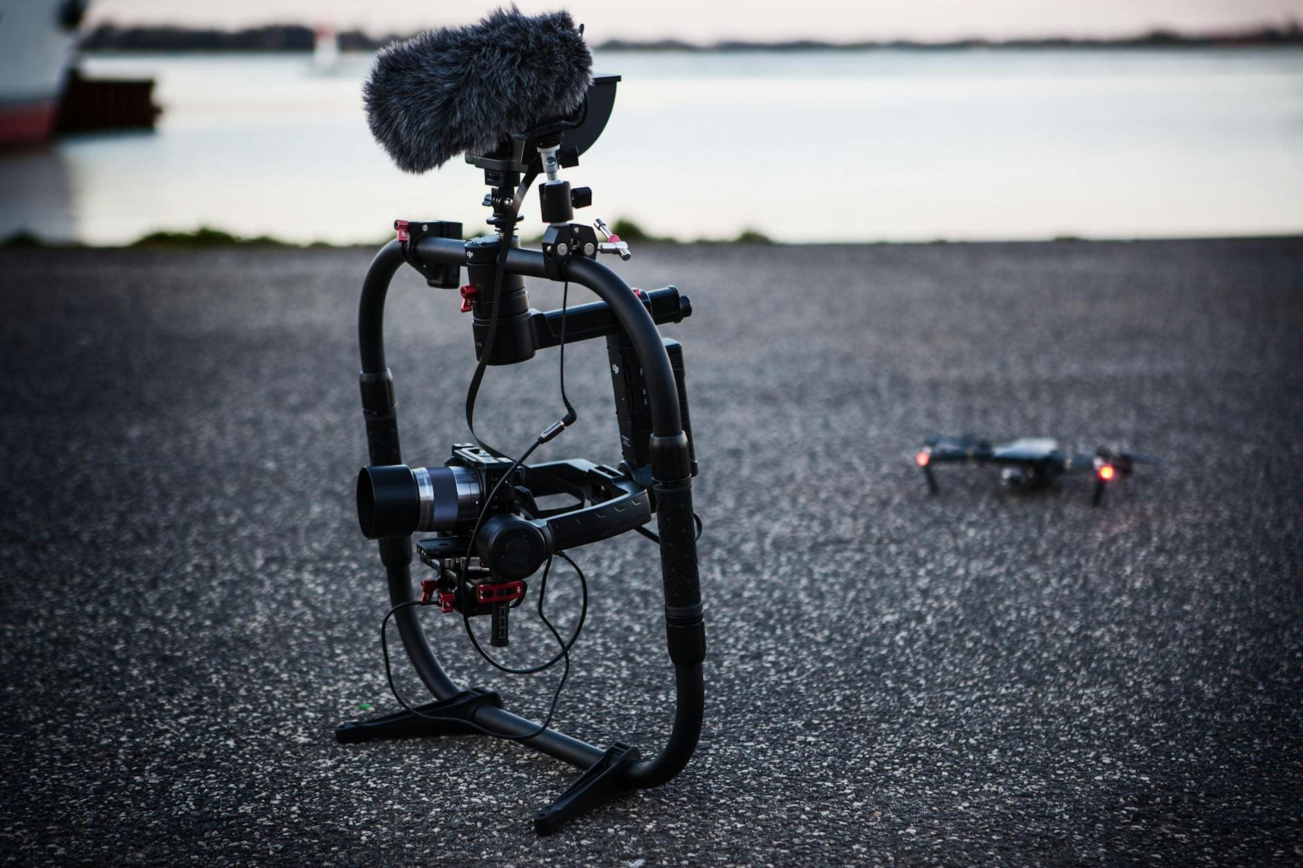 shallow focus photography of black quadcopter near body of water