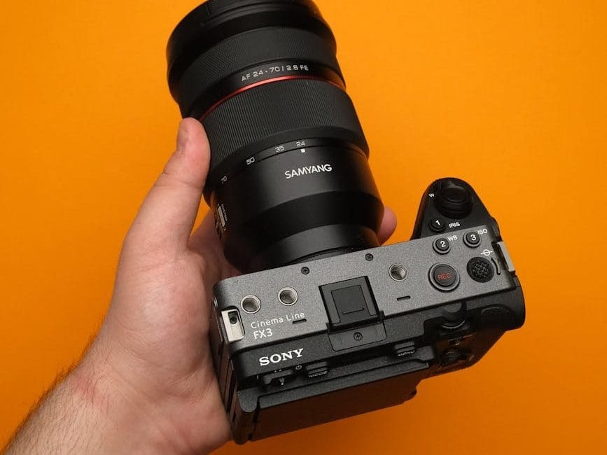 professional video camera held against orange background